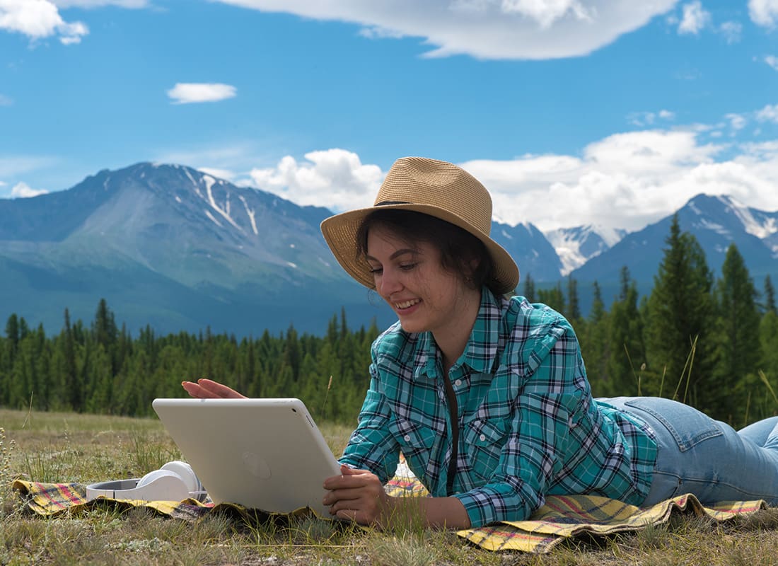 Read Our Reviews - Young Woman in the Hat Using Tablet Computer on Mountains Background